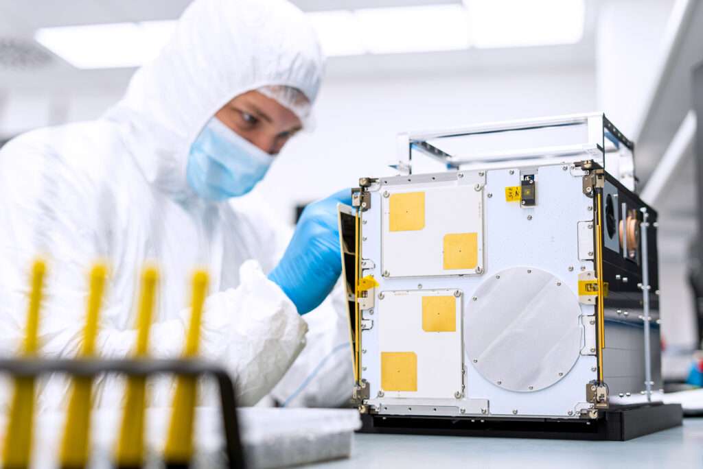 A satellite assembly engineer working on a 12U CubeSat.